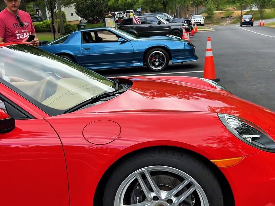 A red sports car and a classic car at the festival car show